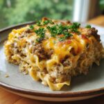 A delicious slice of Creamy Beef and Noodle Casserole topped with melted cheese and parsley.