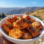A bowl of perfectly cooked crispy salmon bites seasoned with herbs, ready to be enjoyed.
