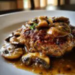 A close-up of Easy Homemade Salisbury Steak smothered in rich mushroom gravy.