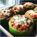 Close-up of green Easy Stuffed Bell Peppers filled with rice and meat mixture, topped with melted cheese.