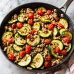 Close-up of a one pan healthy turkey and zucchini skillet with cherry tomatoes and herbs.
