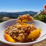 A spoonful of warm Peach Crisp with Oat Crumble Topping, showing juicy peaches and crunchy oats.