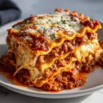A hearty slice of Slow Cooker Ravioli Lasagna with layers of pasta, meat sauce, and melted cheese.