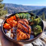 A delicious Teriyaki Salmon Bowl Healthy Meal with rice, salmon, broccoli, carrots, and cucumber.