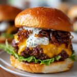 A close-up of a delicious caramelized onion smash burger, featuring a brioche bun, melted cheese, juicy patty, and creamy sauce.
