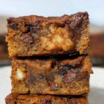 Close-up of stacked Easy Banana Bread Brownies, showing gooey chocolate chips and banana chunks.