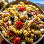 A vibrant bowl of Easy Italian Pasta Salad with Fresh Veggies and Chicken, featuring rotini pasta, cherry tomatoes, olives, feta, and red onion.
