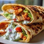 Two High Protein Cottage Cheese Flatbread Chicken Wraps filled with grilled chicken, lettuce, tomato, red onion, and creamy sauce.
