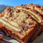 Close-up of moist slices of High Protein Greek Yogurt Banana Bread with visible banana slices and chocolate chips.