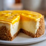 A delicious slice of no bake mango cheesecake with a graham cracker crust and smooth mango topping.