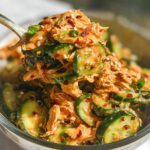 A close-up of Thai Cucumber Chicken Salad with Peanut Dressing, featuring shredded chicken, sliced cucumbers, and a creamy peanut sauce.