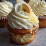 Close-up of a Best Ever Banana Pudding Cupcake topped with creamy frosting, banana slice, and pudding.