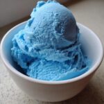 Close-up of a white bowl filled with scoops of bright blue Blue Moon Ice Cream Recipe.