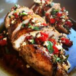 Close-up of sliced Bruschetta Stuffed Chicken, showcasing the tomato and cheese filling with fresh basil.