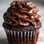 Close-up of a decadent Chocolate Caramel Cupcake with swirls of chocolate frosting and rich caramel drizzle.