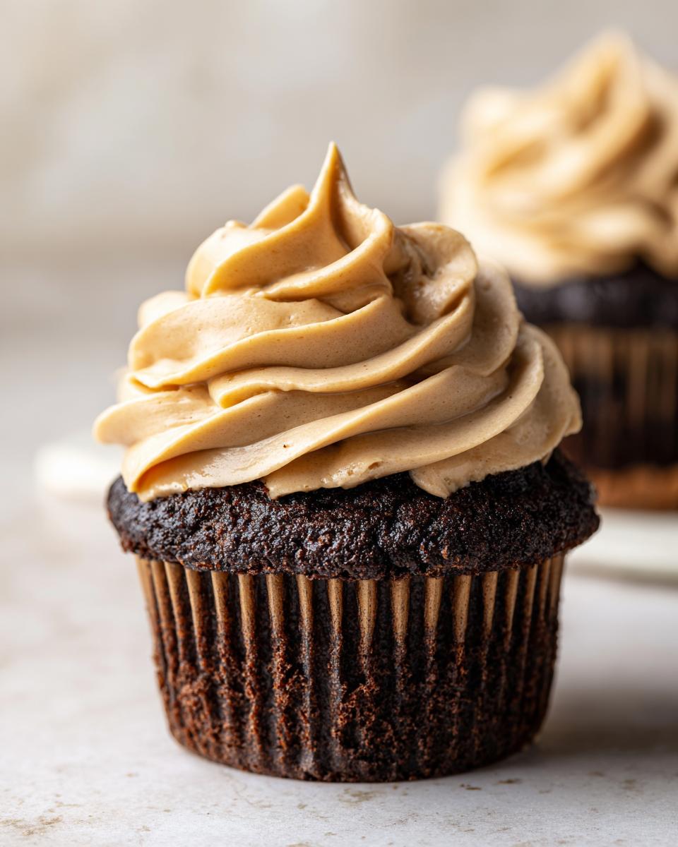 Decadent Chocolate Cupcakes with Peanut Butter Buttercream 4 Close-up of a rich chocolate cupcake topped with swirls of creamy peanut butter buttercream.