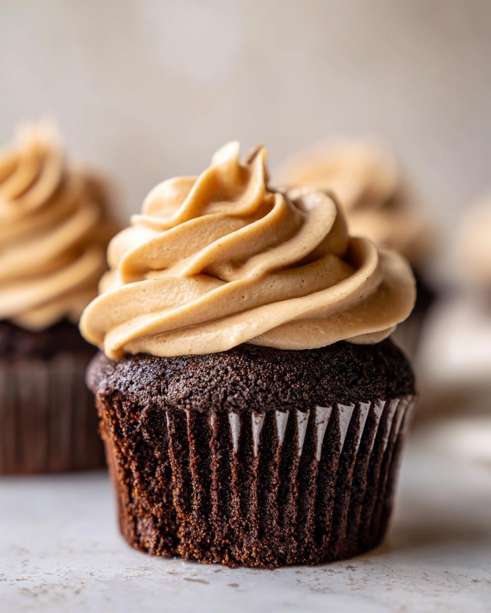 Decadent Chocolate Cupcakes with Peanut Butter Buttercream 5 Close-up of a rich chocolate cupcake topped with creamy peanut butter buttercream frosting.