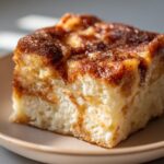 A delicious slice of Churro Cheesecake French Toast Bake on a plate, showcasing cinnamon swirls and fluffy texture.