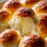 Close-up of fluffy soft dinner rolls dough, showcasing their tender texture and golden-brown tops.