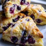 Close-up of delicious Easy Lemon Blueberry Scones with a sweet glaze and fresh blueberries.