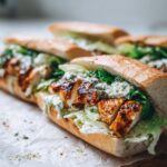 Close-up of a delicious Garlic Butter Chicken Caesar Sandwich filled with grilled chicken, lettuce, and creamy Caesar dressing.