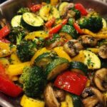 Close-up of healthy sautéed vegetables quick, featuring broccoli, zucchini, bell peppers, and mushrooms in a pan.