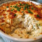 A close-up of Joe's Crab Shack Inspired Crab Dip, bubbling and golden brown with green onions.