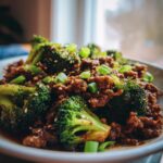 Close-up of a Keto Ground Beef and Broccoli Bowl, garnished with sesame seeds and green onions.