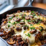 Close-up of a Keto Hamburger Mushroom Swiss Skillet, bubbling with melted cheese and topped with fresh parsley.