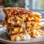 A stack of golden-brown Mac and Cheese Stuffed Quesadillas with gooey cheese stretching out.