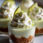 Close-up of a No Bake Key Lime Pie Cup topped with whipped cream, lime zest, and a lime wedge.