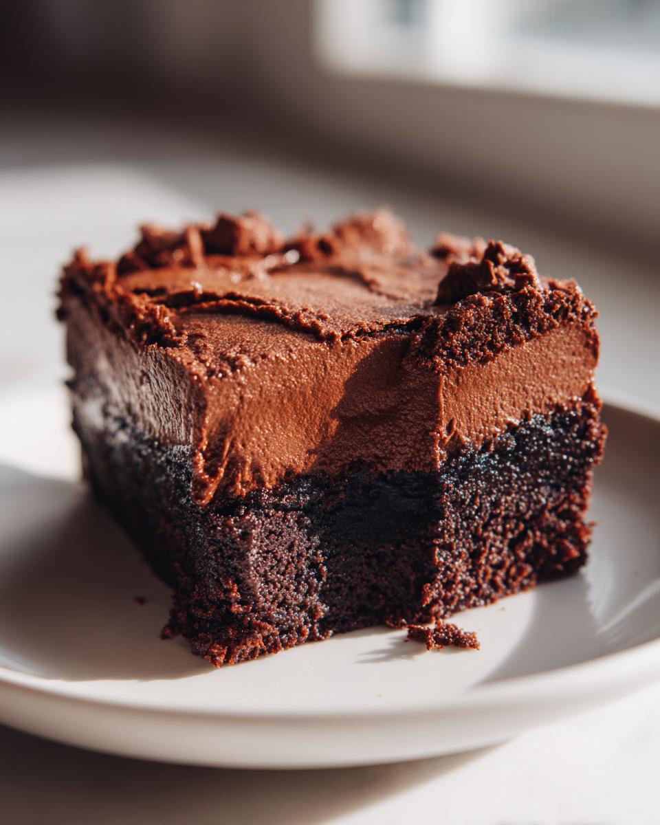 Irresistible Rich Chocolate Mousse Brownies 4 A decadent slice of Rich Chocolate Mousse Brownies, featuring a dense chocolate brownie base topped with smooth chocolate mousse.
