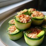 Close-up of Spicy Tuna Cucumber Sushi Rolls, featuring a filling of tuna and avocado, topped with sesame seeds and paprika.