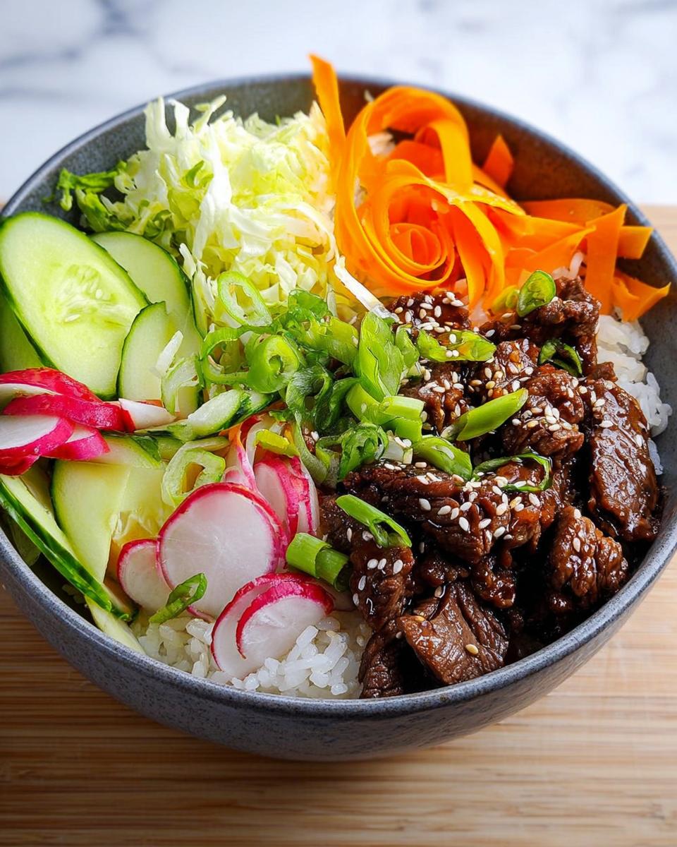 Speedy Teriyaki Beef Poke Bowl Delight 4 A delicious Teriyaki Beef Poke Bowl with Rice and Veggies, featuring tender beef, white rice, cucumber, radish, cabbage, and carrots.